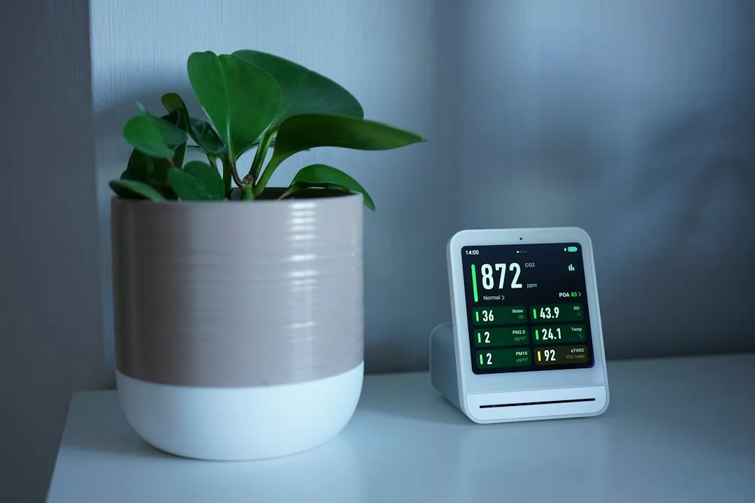 Wall-mounted ambient air quality sensor with numerical readings and color gradient indicator