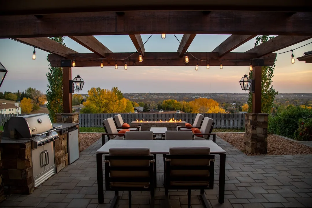 Modern patio outdoor kitchen island with stainless steel grill and seating