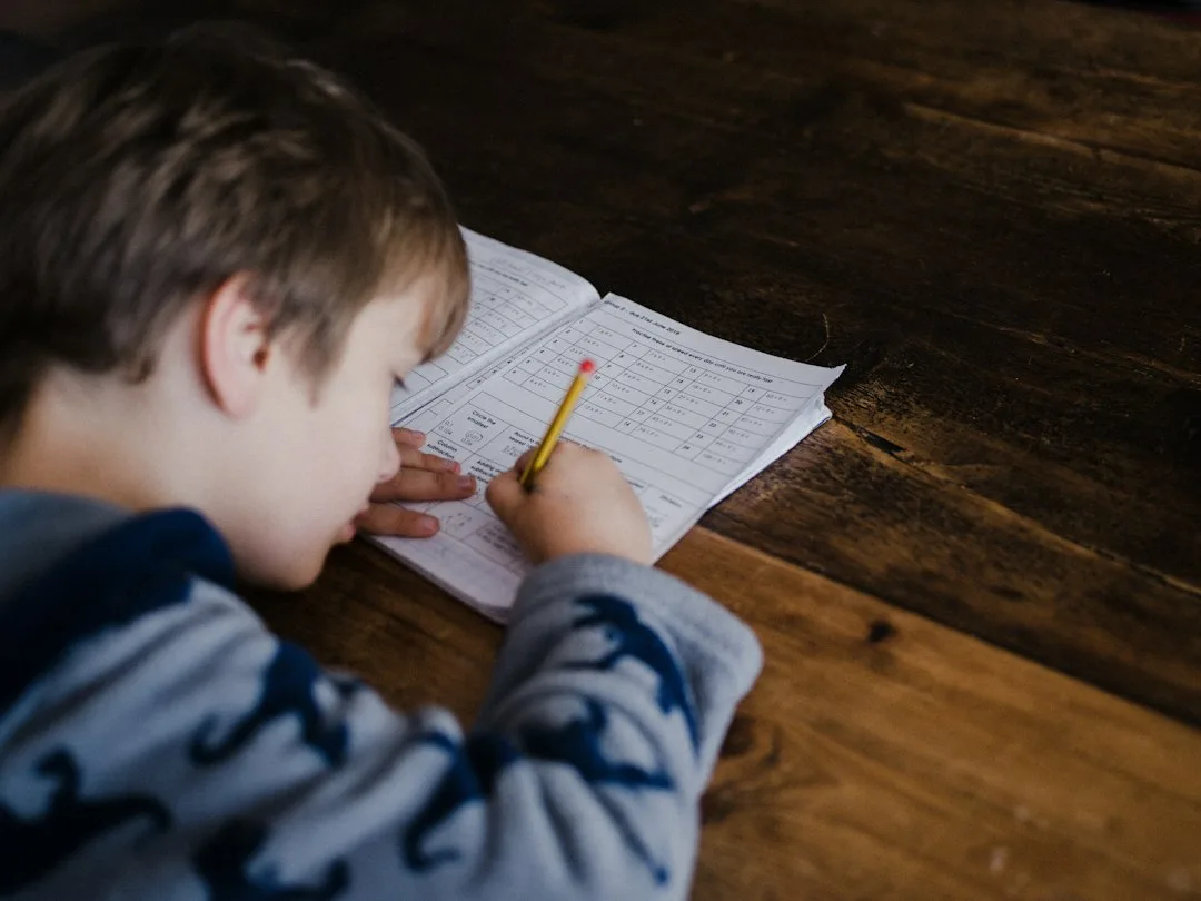 Child at desk with organized school supplies, clock, and snack during afterschool routine structure