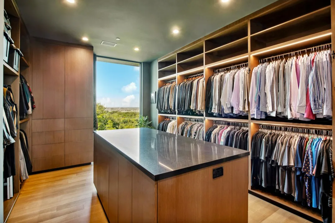 Luxury walk-in closet island with open shelving and jewelry display zone