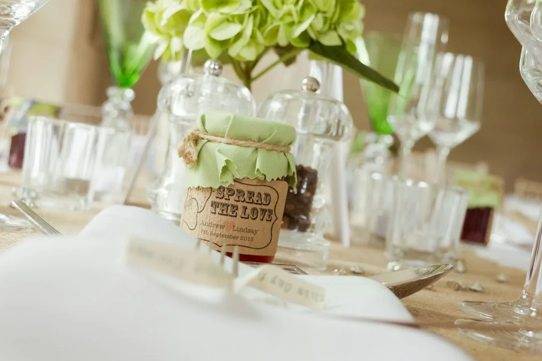 Artisan wedding favors featuring local honey jars with custom labels and dried flower arrangements
