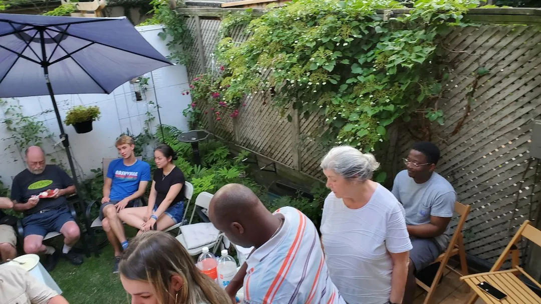 Curated summer gathering featuring long wooden table seated 25 people