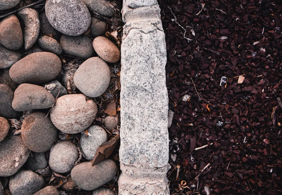 Layered natural stone border defining modern garden bed edge