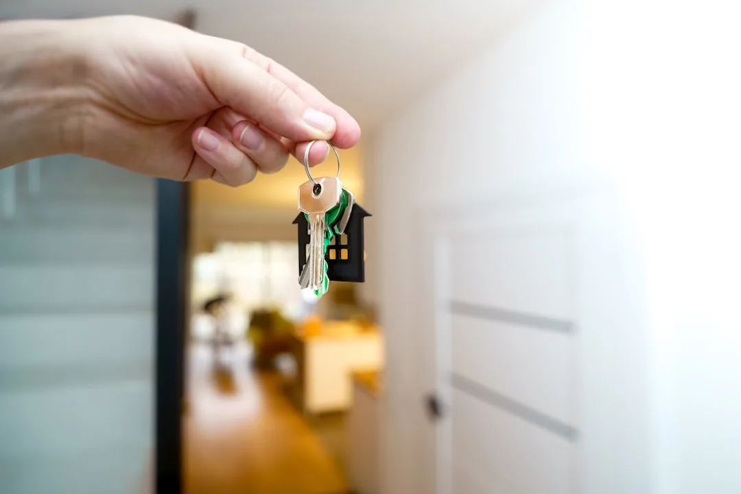 Two apartment swaps travel participants exchanging keys in modern city apartment lobby