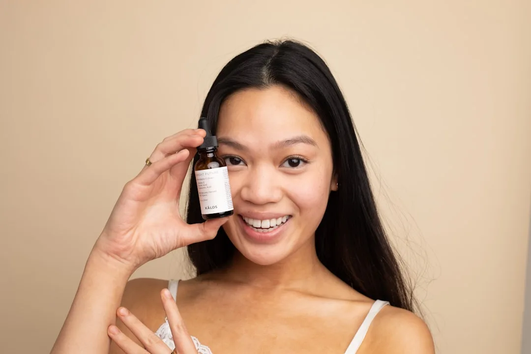 Woman applying retinol serum to cheek in well-lit bathroom mirror