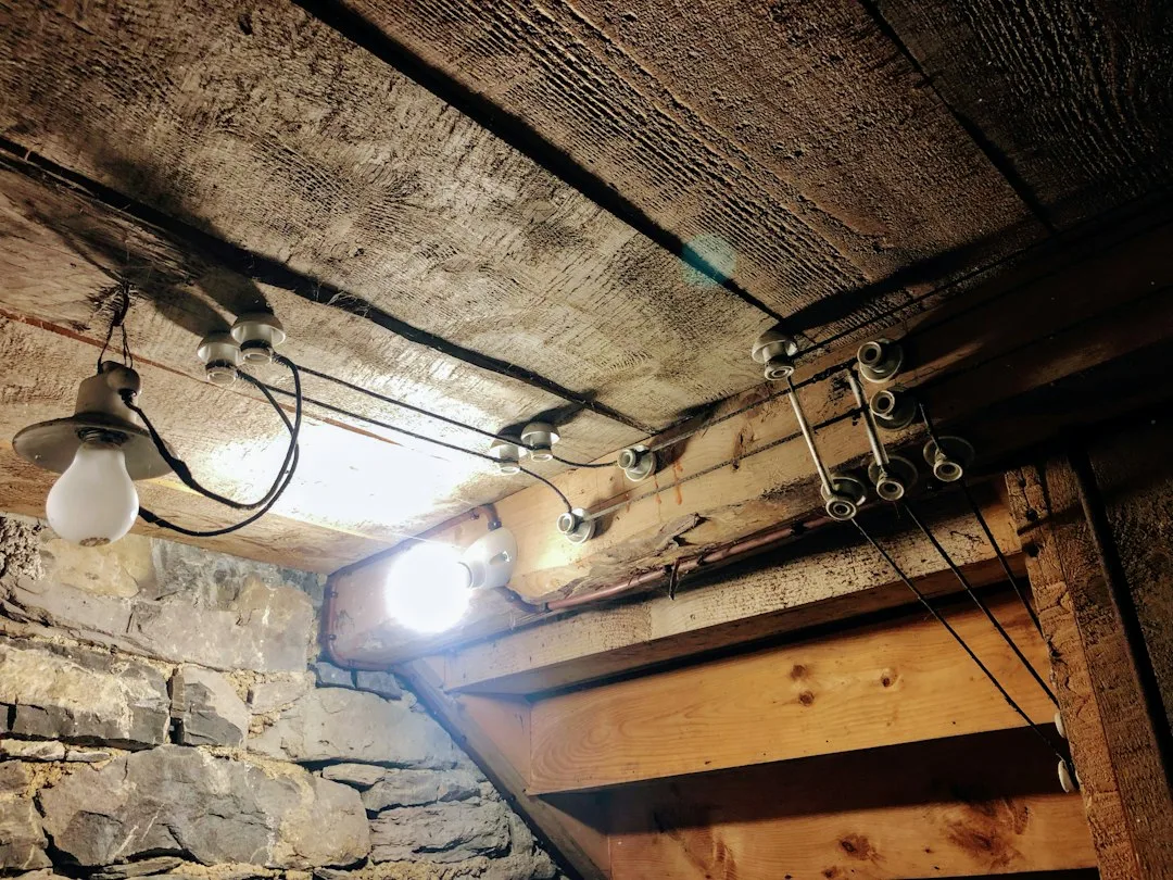 Basement ceiling with exposed joists showing moisture prevention foam insulation installed
