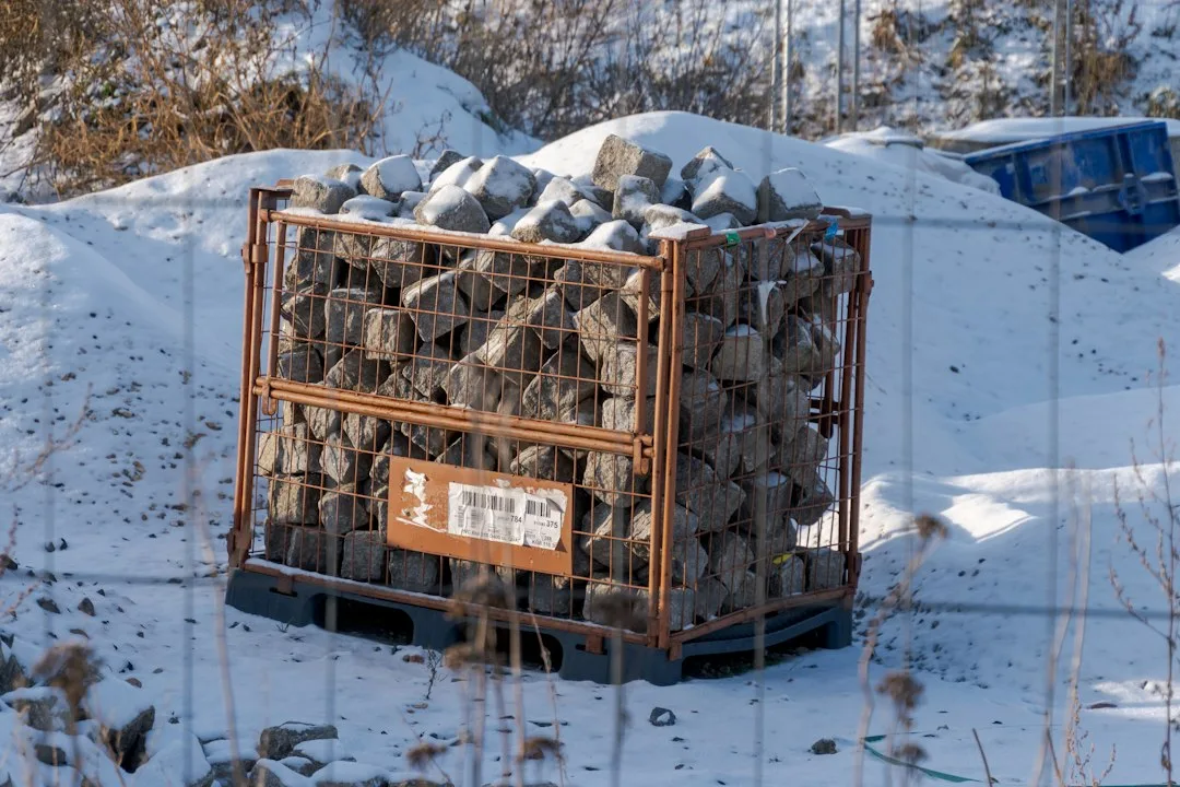 Gabion wall landscaping feature creating modern privacy screen with layered stone and steel basket structure