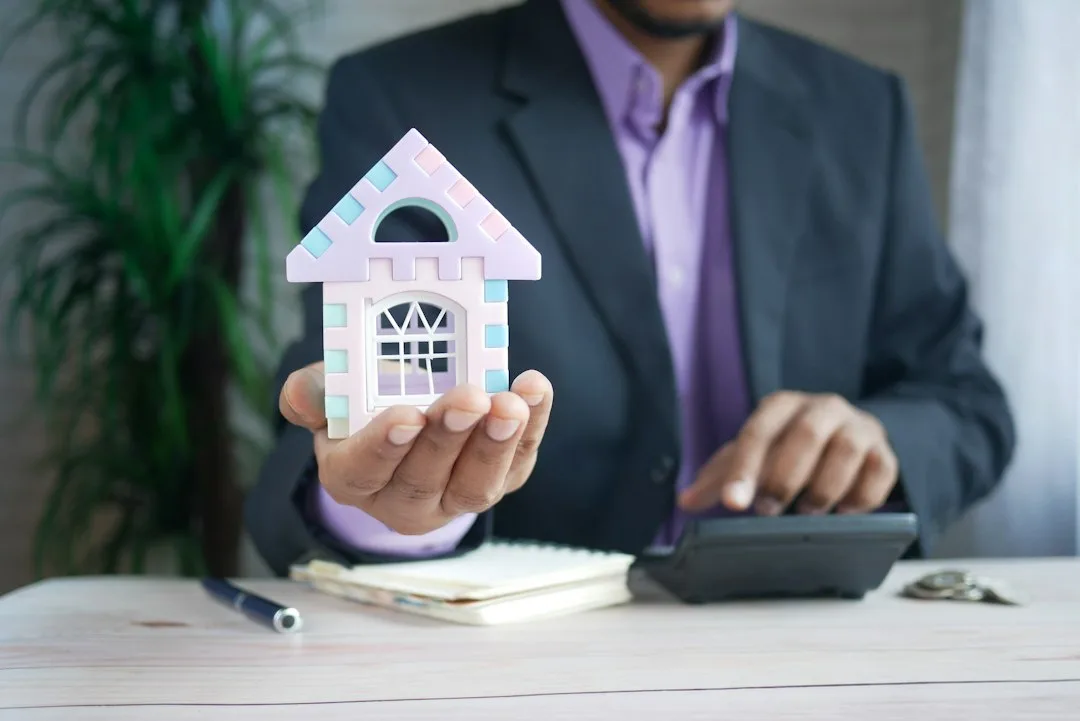 Buyer and agent reviewing a mortgage transfer document at a kitchen table