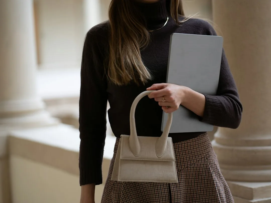 Corduroy trousers styled with knitwear and a camel coat for office wear
