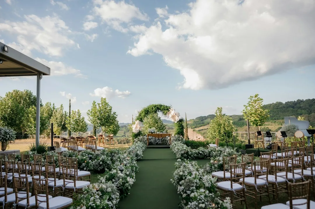 Wedding aisle runners framing an outdoor ceremony with white chairs