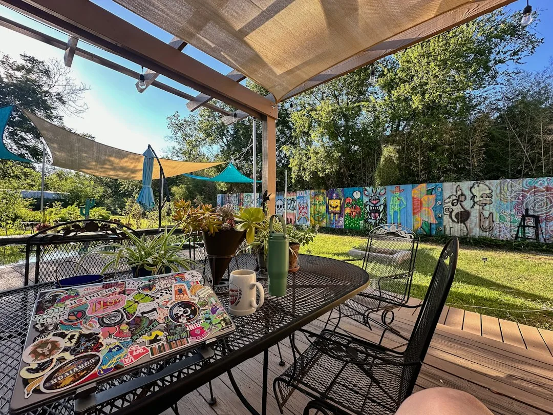 Triangular shade sail installation over patio seating area with tension cables