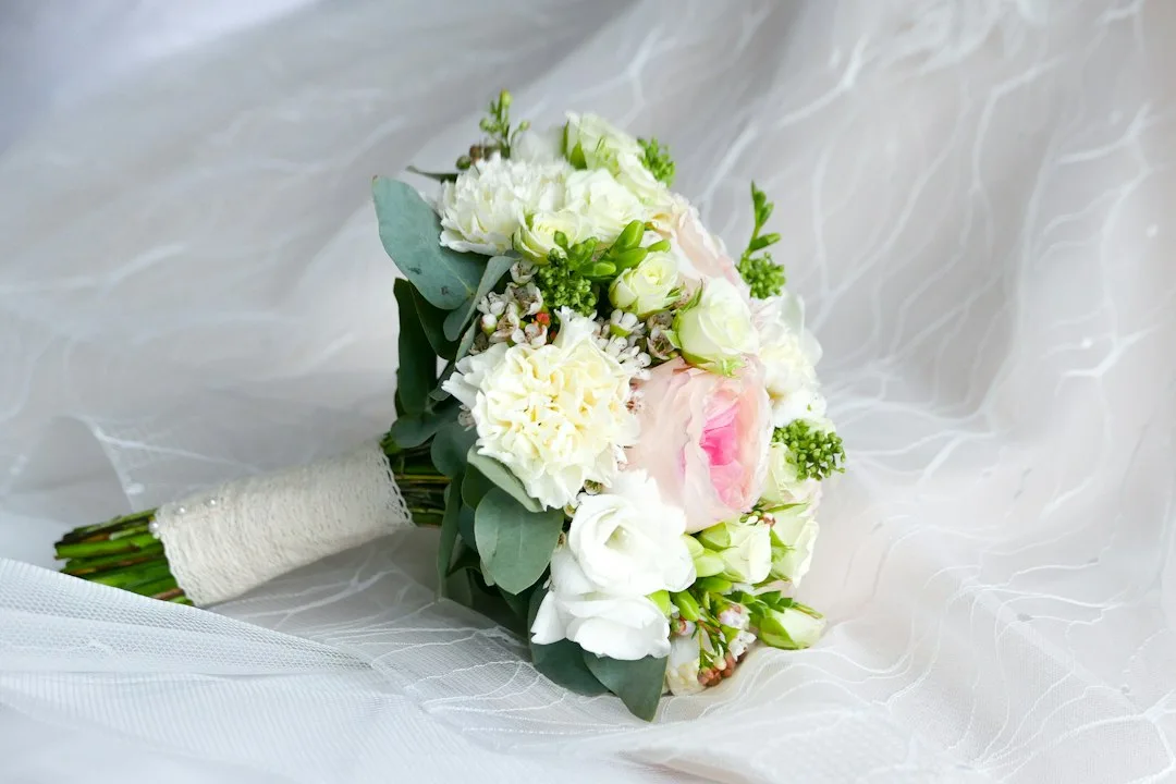 Hand-tied bouquet of garden roses and ranunculus with a natural, spiraling shape