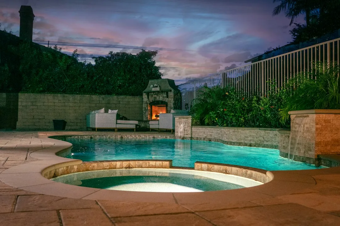 Backyard hot tub placement on a level patio beside a privacy screen