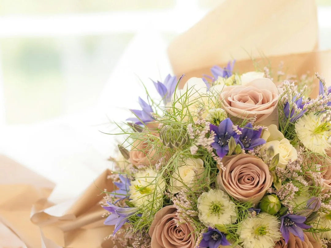 Close-up of eucalyptus and ruscus greenery supporting a loose cascading bridal bouquet