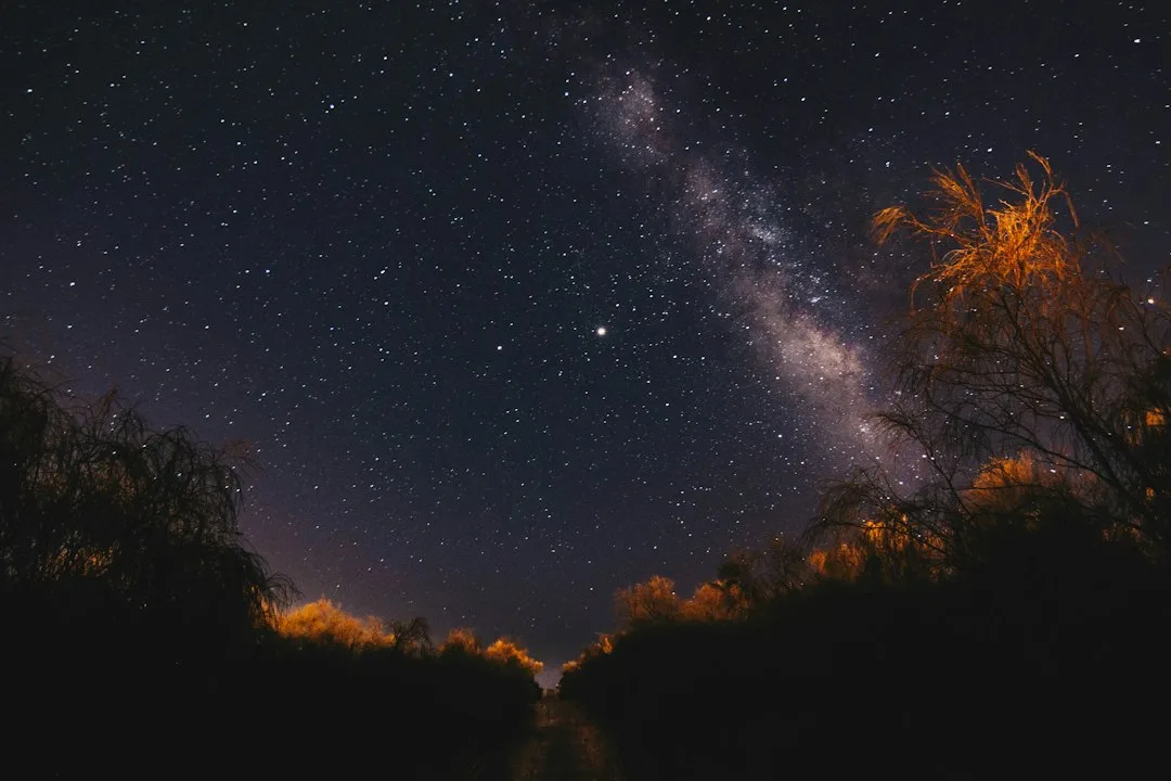 Red headlamp and binoculars resting on a folding table at a night sky viewing spot
