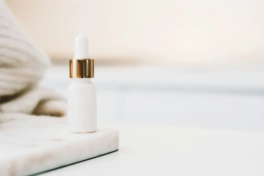 Lash serum tube with a fine applicator brush on a bathroom counter