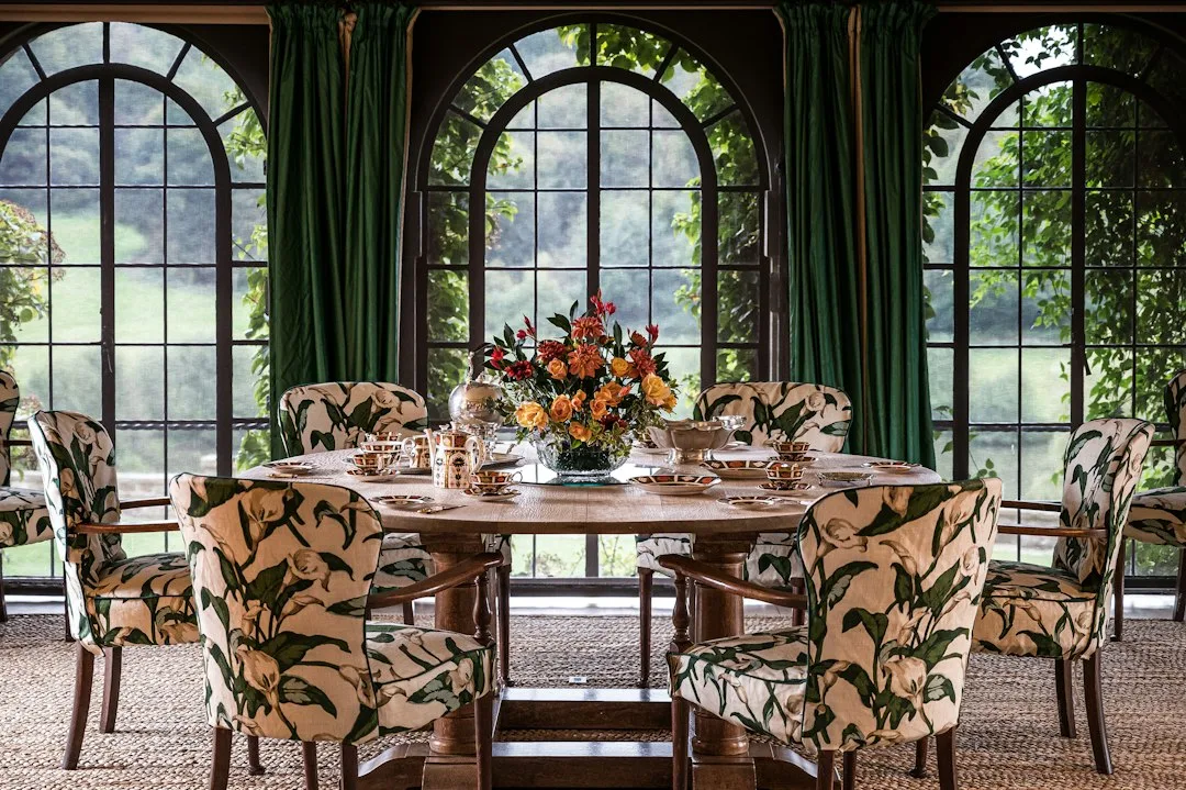 Cane dining chairs around an oak table in a bright room