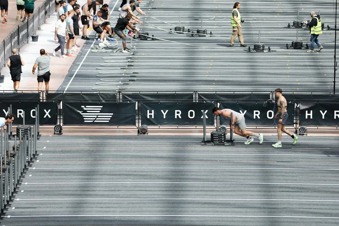 Athlete pushing a sled during Hyrox training session in gym