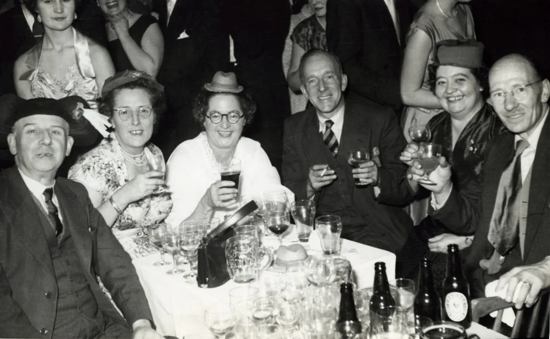 Guests at a murder mystery dinner party reading clue cards by candlelight
