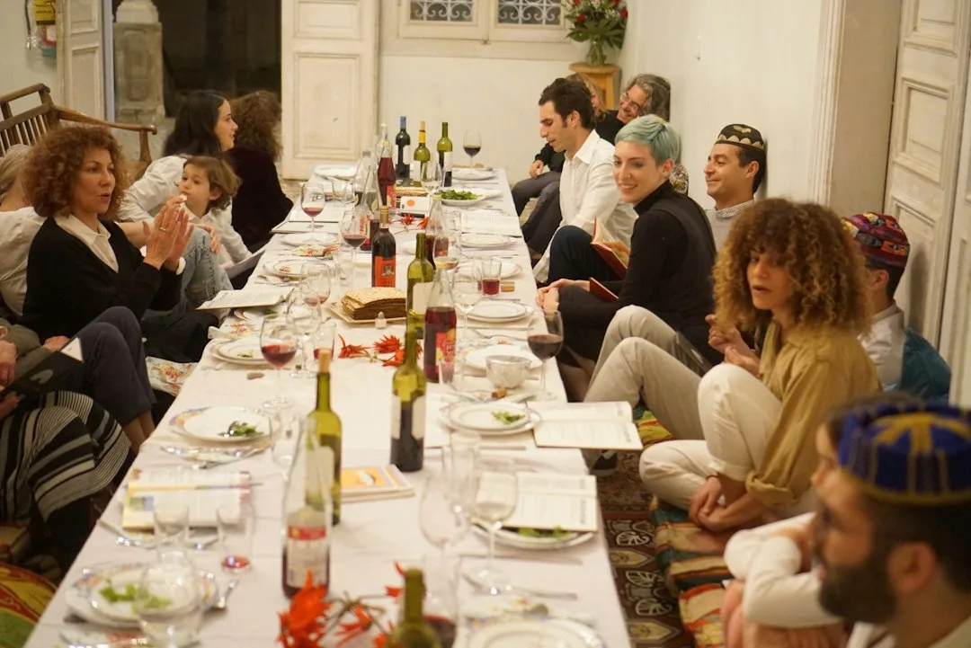 Host reading a sealed clue envelope during a murder mystery dinner with costumed guests